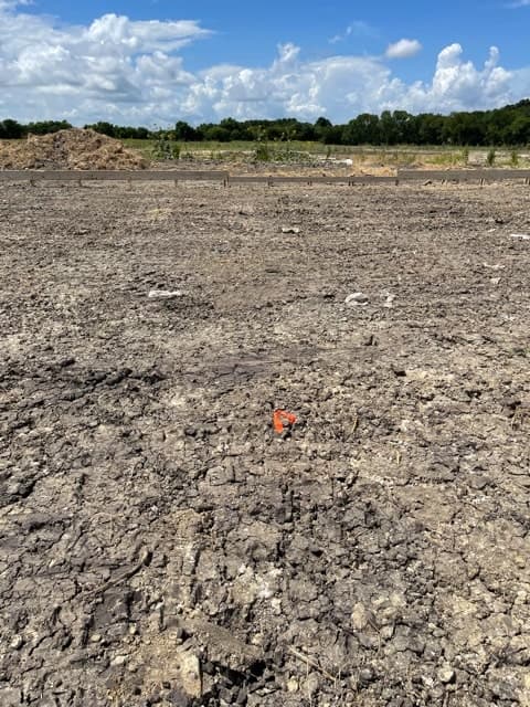Building pad prepared for a residential slab, checked during a pad elevation survey.